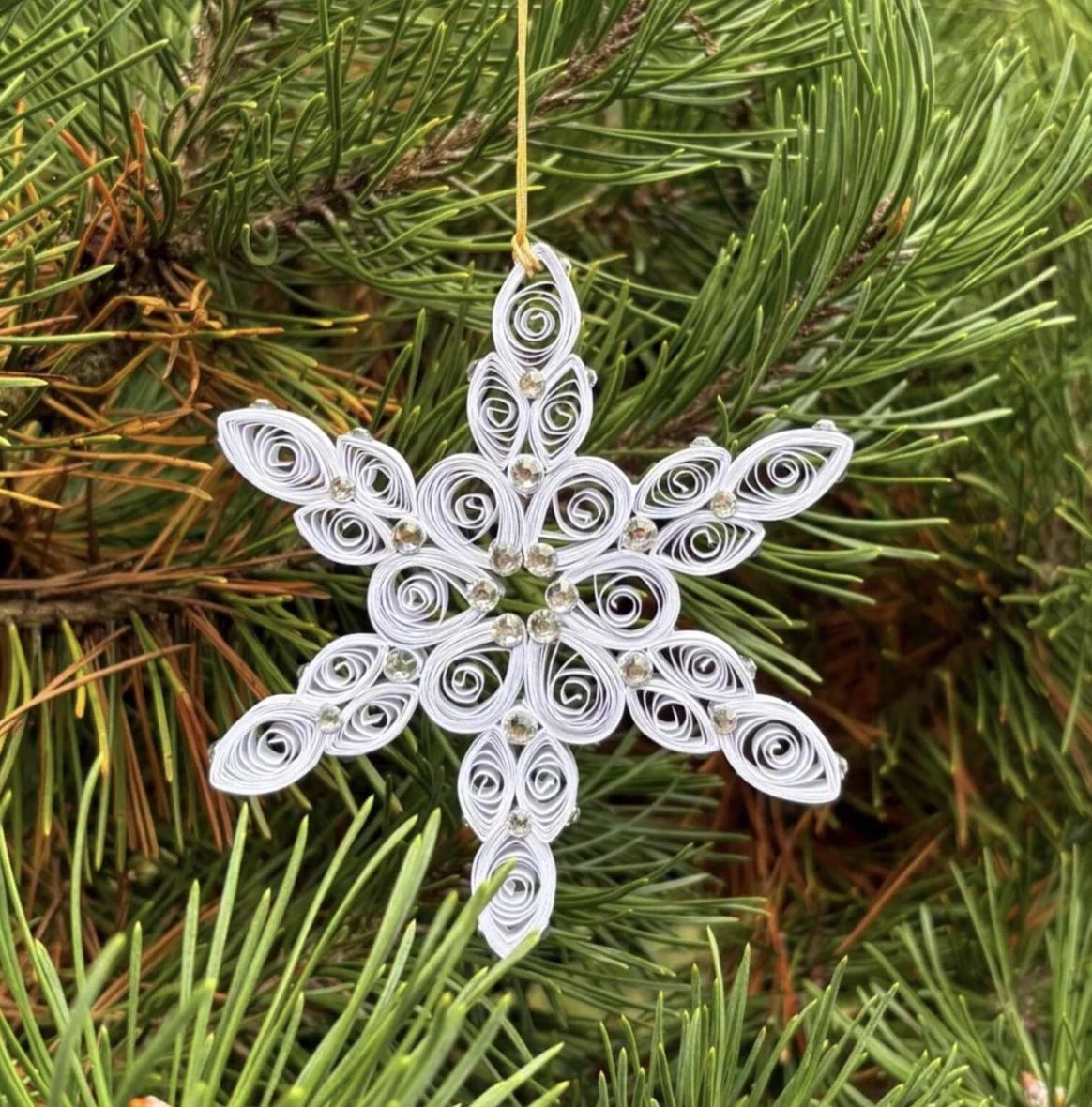 Hand-quilled paper Christmas ornament featuring intricate dimensional paper coils and delicate pearl embellishments.