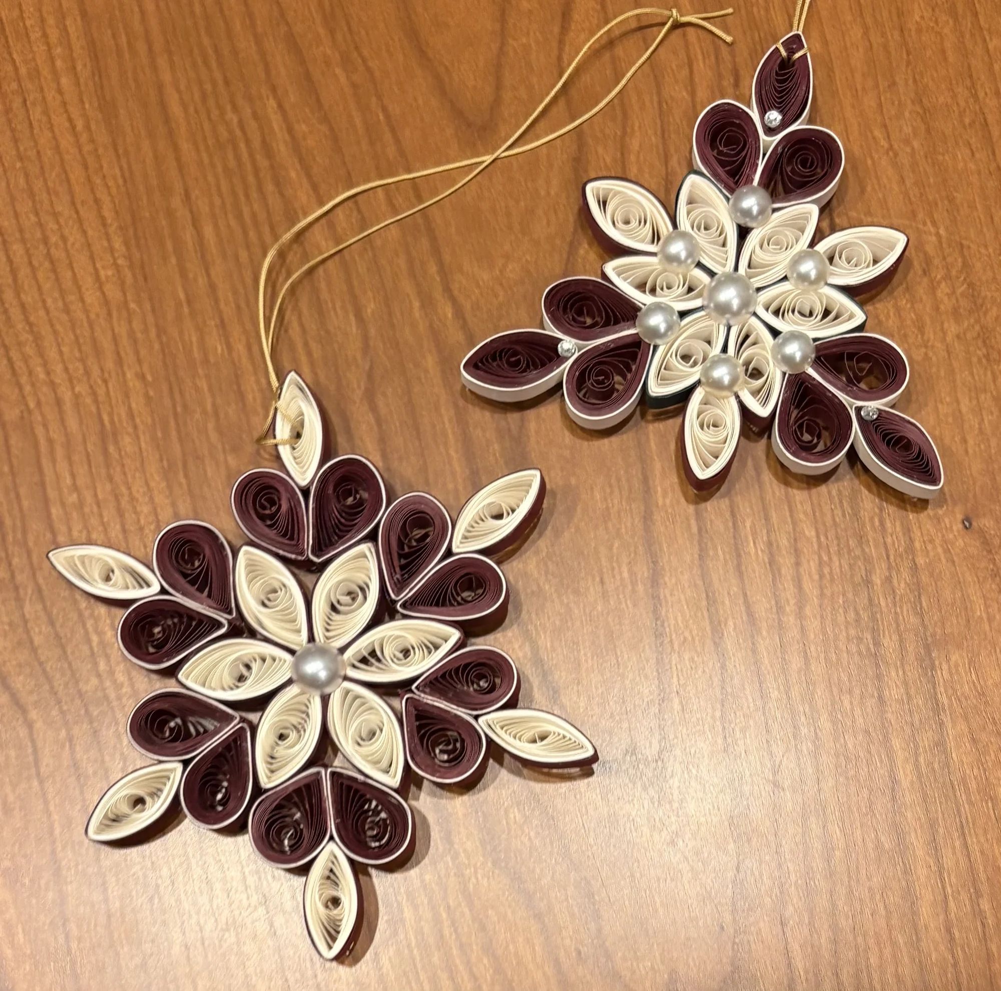 Hand-quilled paper Christmas ornament featuring intricate dimensional paper coils and delicate pearl embellishments.