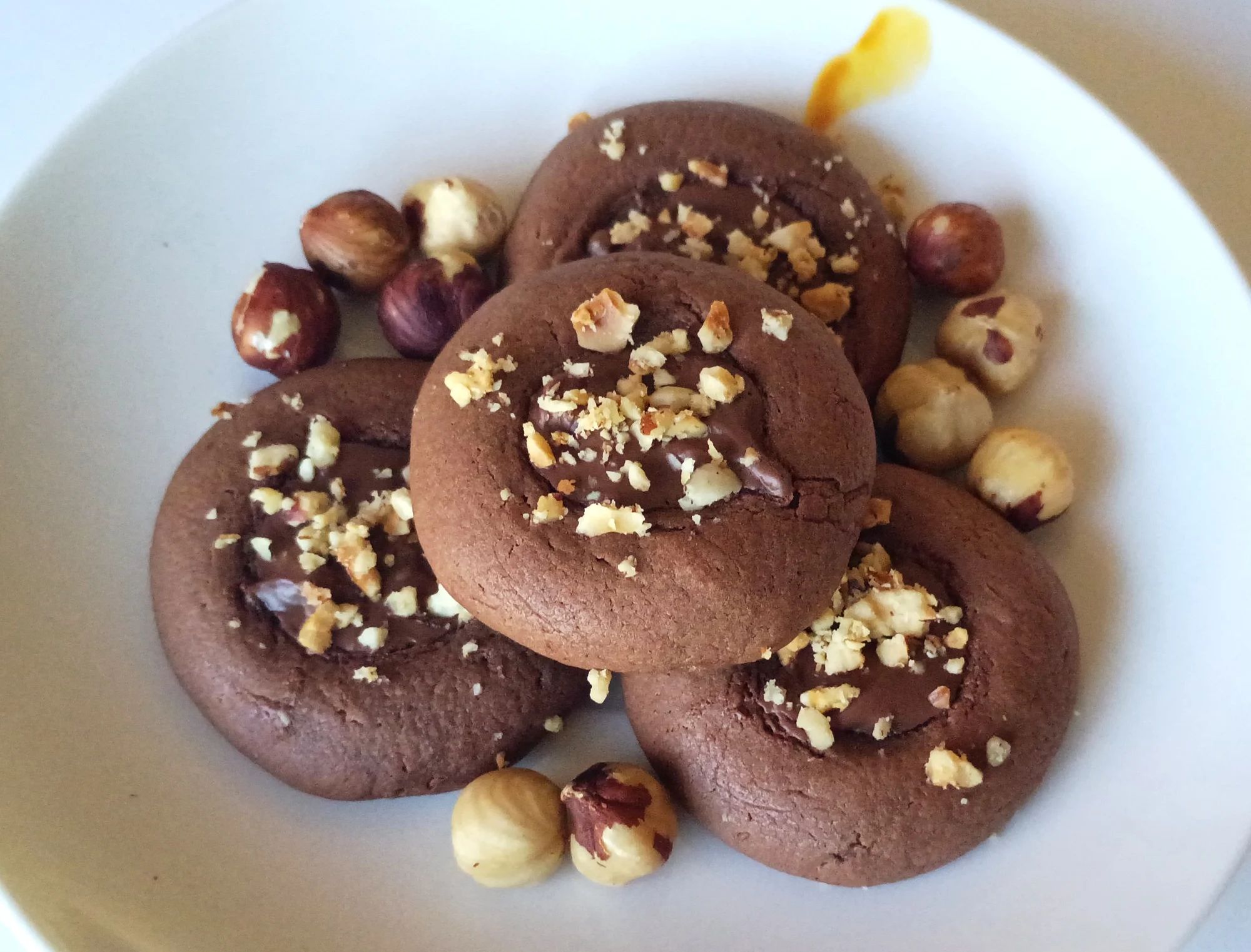 Nutellotti are delicious and rich Italian cookies made with just a few ingredients. They are topped with hazelnut cream and sprinkled with chopped hazelnuts.