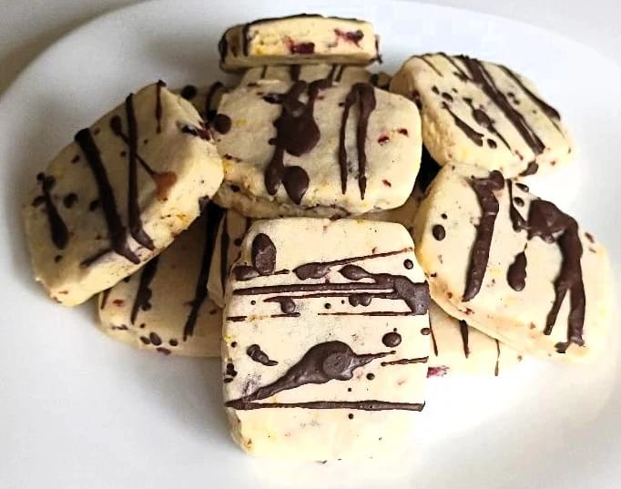 These cranberry-orange shortbread cookies are the perfect combination of fruity and chocolaty. The batter is filled with cranberry and orange zest, then finally drizzled with chocolate, giving them an artistic appearance.
