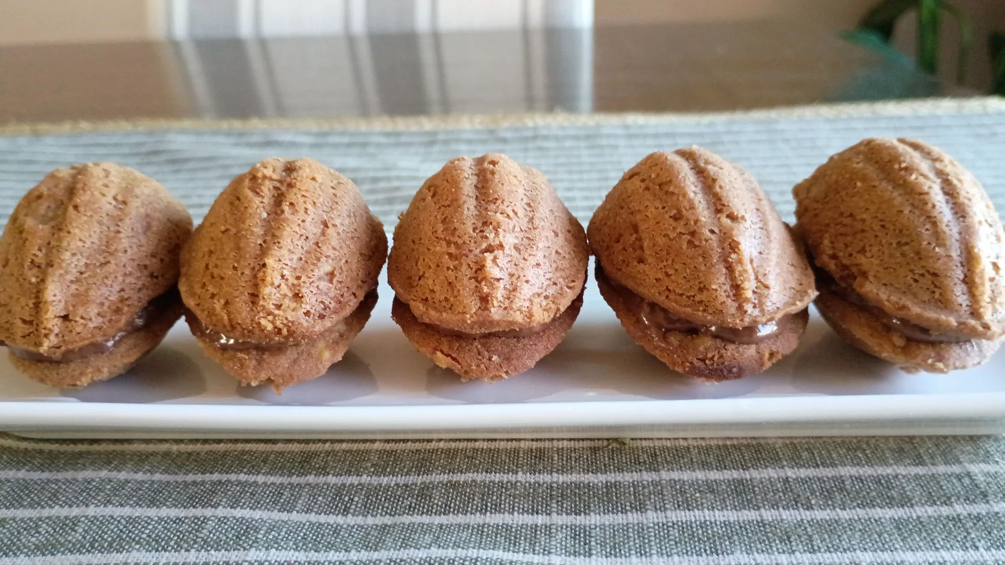 Using two molds in the shapes of a walnut shell, the chocolate and nutty batter is molded and sealed together with a sweet hazelnut spread.