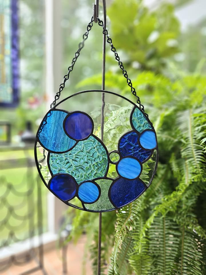 Stained glass circle filled with various colors and textures of blue glass